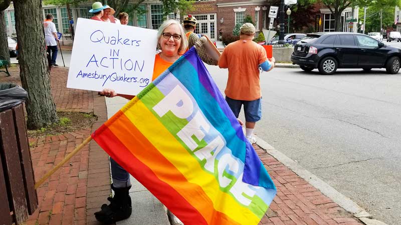 Edith holding Quakers in Action sign and peace flag