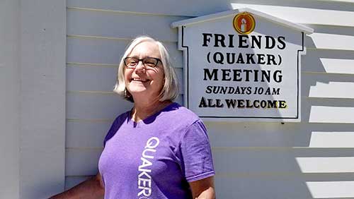 Woman outside meetinghouse with Quaker T Shirt